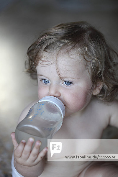 Caucasian baby girl drinking bottle