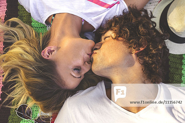 Junges Paar  das sich auf der Decke küsst