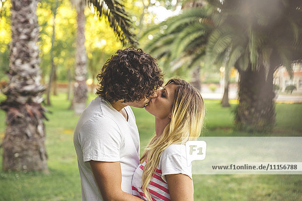 Young couple kissing in park