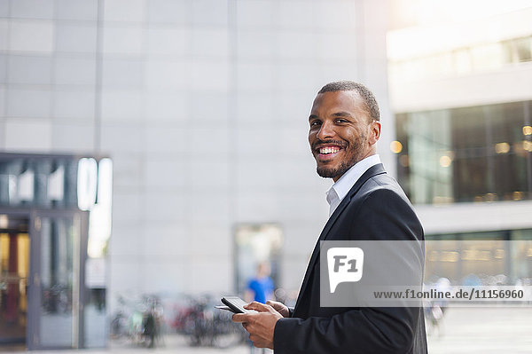Portrait of smiling businessman with mini tablet
