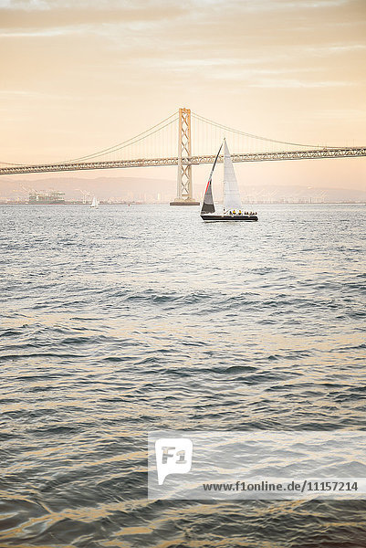 USA  San Francisco  Segelboot gegen Bay Bridge bei Sonnenuntergang