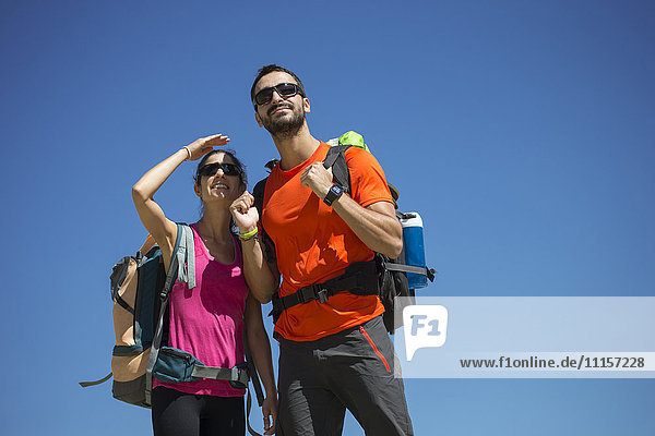 Hiking couple looking out under blue sky