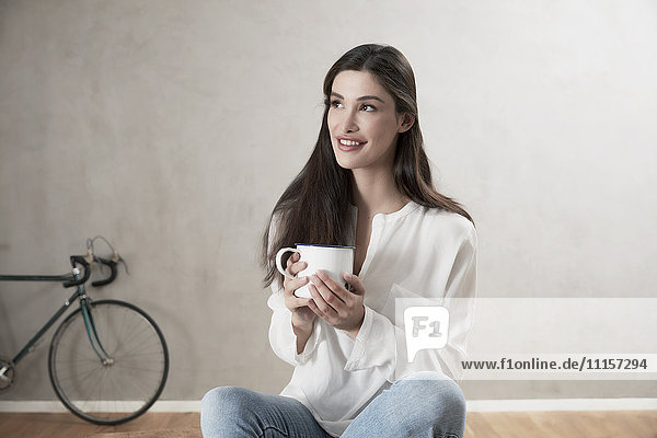 Porträt einer lächelnden Frau bei einer Tasse Kaffee