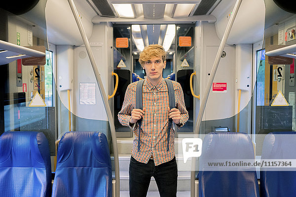 Young man with backpack standing in a train