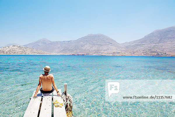 Griechenland  Kykladen  Amorgos  Mann am Rande eines hölzernen Piers  Insel Nikouria