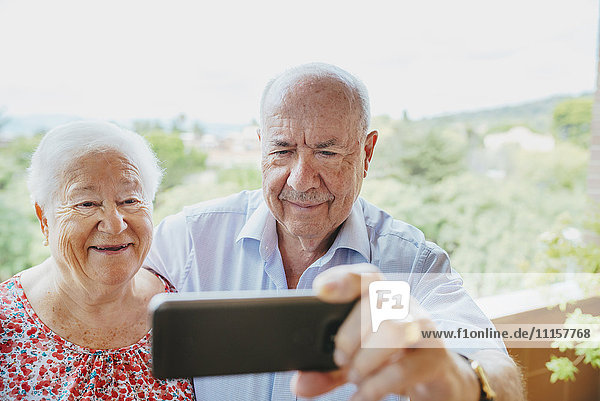 Glückliches Senior-Paar  das einen Selfie mit Smartphone nimmt