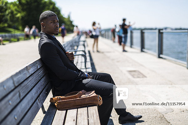 Businessman sitting on bench looking at distance