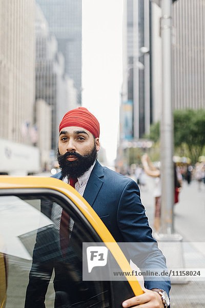Indian businessman in Manhattan entering a yellow cab