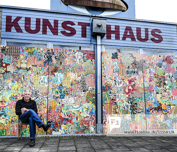 Deutschland  Burghausen  Maler sitzend vor seinem Werk im Kunsthaus