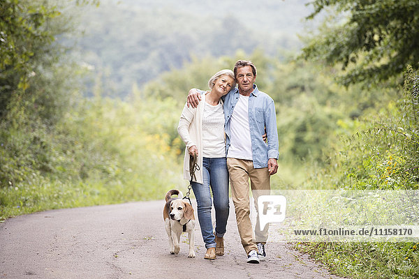 Senior couple on a walk with dog in nature