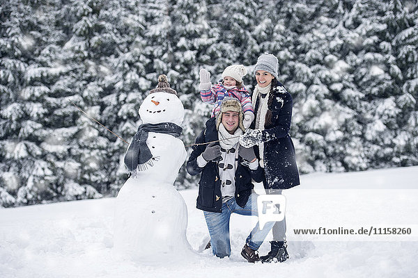 Family posing at snowman