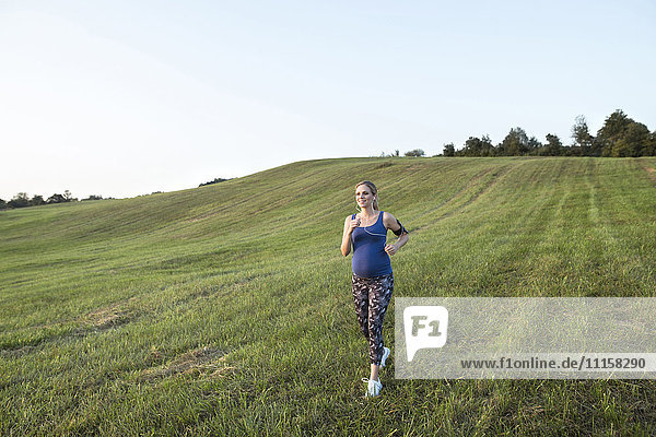 Pregnant woman jogging in field