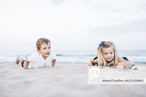 Kleiner Junge und kleines Mädchen beim Spielen am Strand
