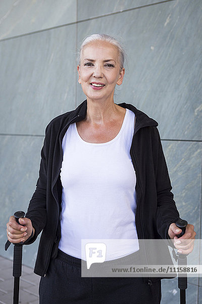 Portrait of smiling woman with walking sticks