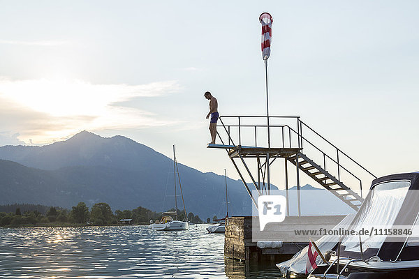 Austria  Sankt Wolfgang  man about to jump from platform into lake