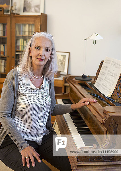 Portrait of woman with piano at home