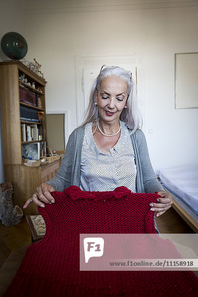 Content woman looking at knitted sweater vest