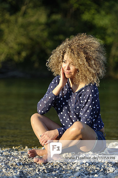 Frau entspannt am Flussufer