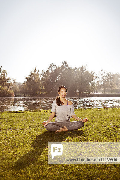 Frau mit geschlossenen Augen entspannt in Lotus-Yoga-Pose
