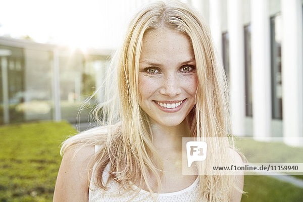 Portrait of smiling young blond woman outdoors