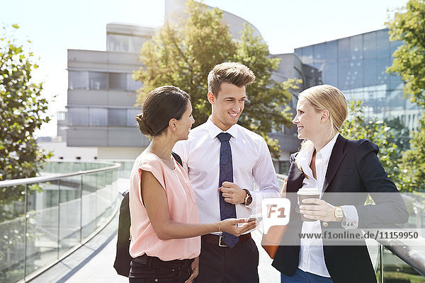 Drei Geschäftskollegen auf einer Kaffeepause im Freien