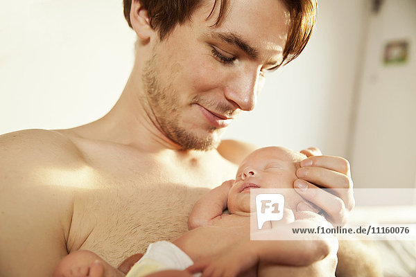 Nackter Vater mit seinem neugeborenen Baby