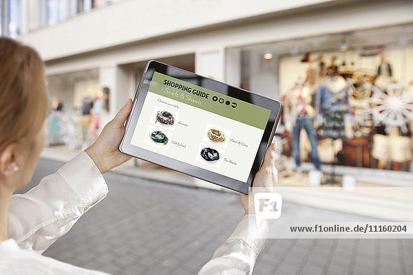 Frau hält ein digitales Tablett mit Online-Einkaufs-Applikation