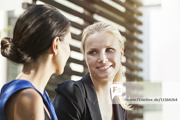 Two businesswomen talking outside