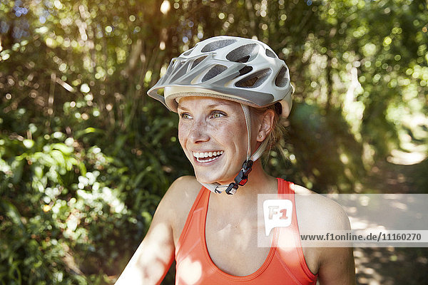 Lachende junge Frau mit Fahrradhelm