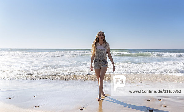 Smiling teenage girl standing at seaside