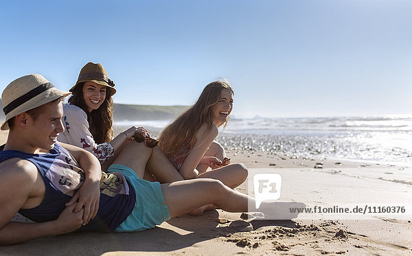 Drei Freunde entspannen sich am Strand
