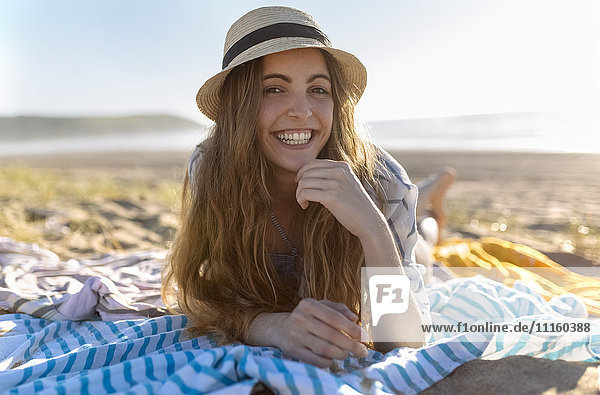 Portrait of smiling teenage girl lying on the beach