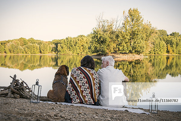 Relaxed senior couple with dog at a lake
