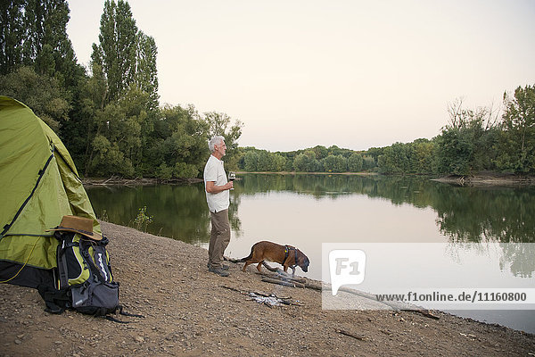 Senior Mann mit Hund Camping am See
