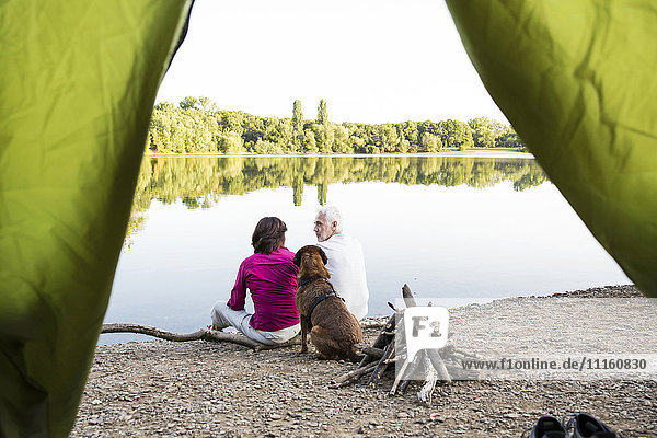 Seniorenpaar Camping mit Hund am See