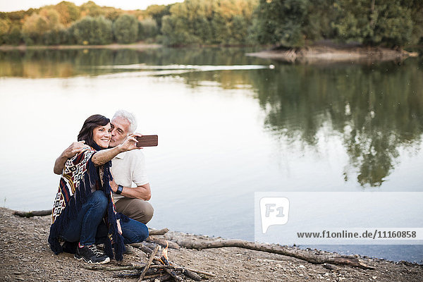 Senior couple at a lake taking a selfie