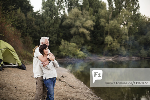Senior couple embracing at a lake