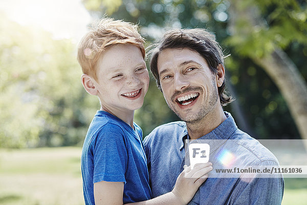 Portrait of happy father with son in garden