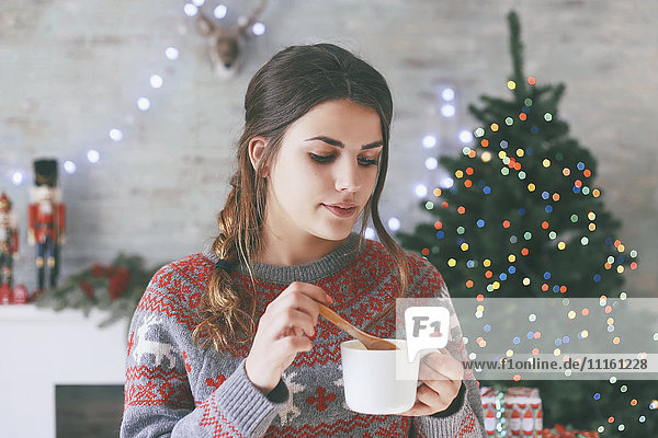 Porträt der Frau mit Tasse Kaffee zur Weihnachtszeit