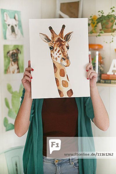 Künstler versteckt hinter dem Aquarell einer Giraffe