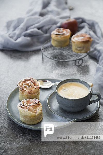 Filo pastry apple cakes in rose shape with cup of coffee