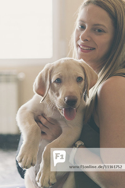 Young woman with her Labrador Retriever puppy