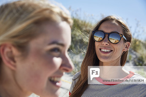 Smiling young woman wearing sunglasses on the beach