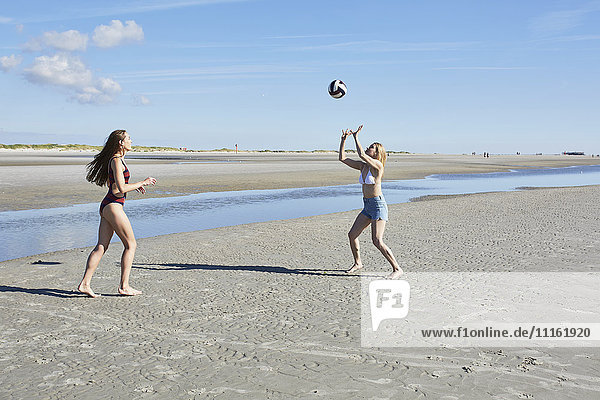 Zwei junge Frauen am Strand beim Beachvolleyball