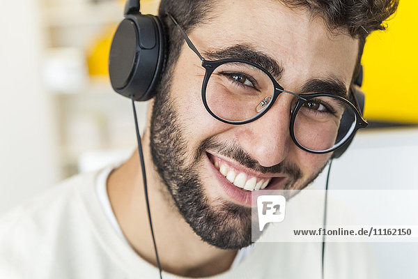 Portrait eines glücklichen Mannes mit Brille und Kopfhörer