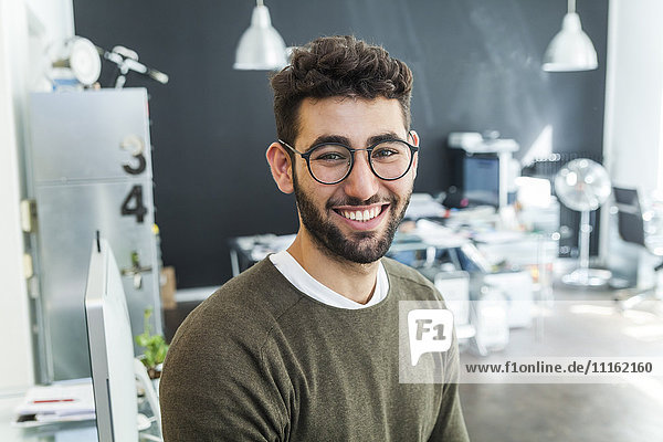 Portrait of smiling man with glasses in a modern office