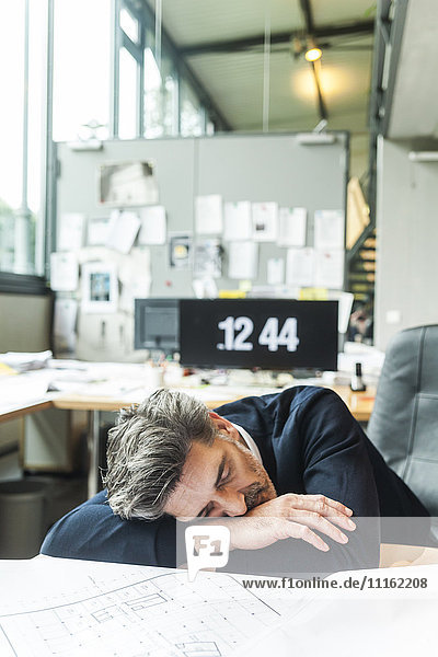 Überarbeiteter Architekt schläft am Schreibtisch