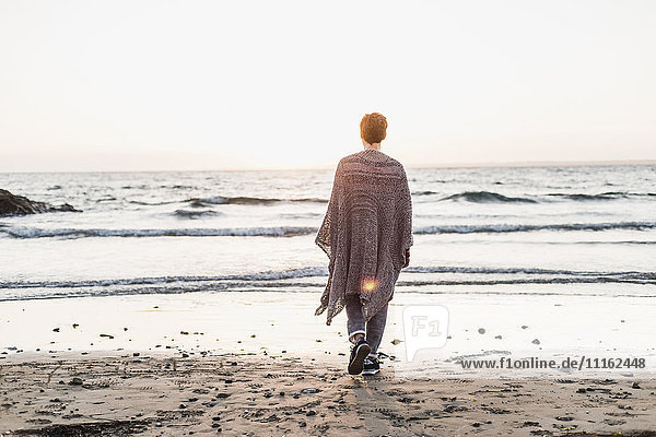 Frankreich  Halbinsel Crozon  Frau  die bei Sonnenuntergang am Strand spazieren geht