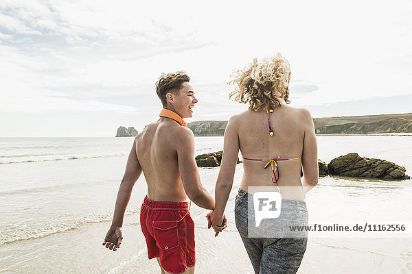 Teenager-Paar beim Spaziergang am Strand