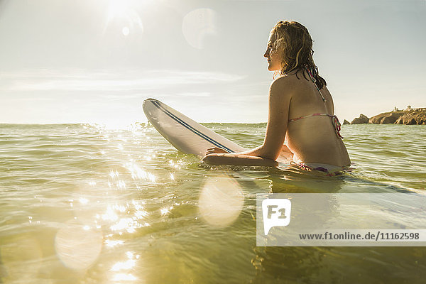 Teenager Mädchen mit Surfbrett im Meer